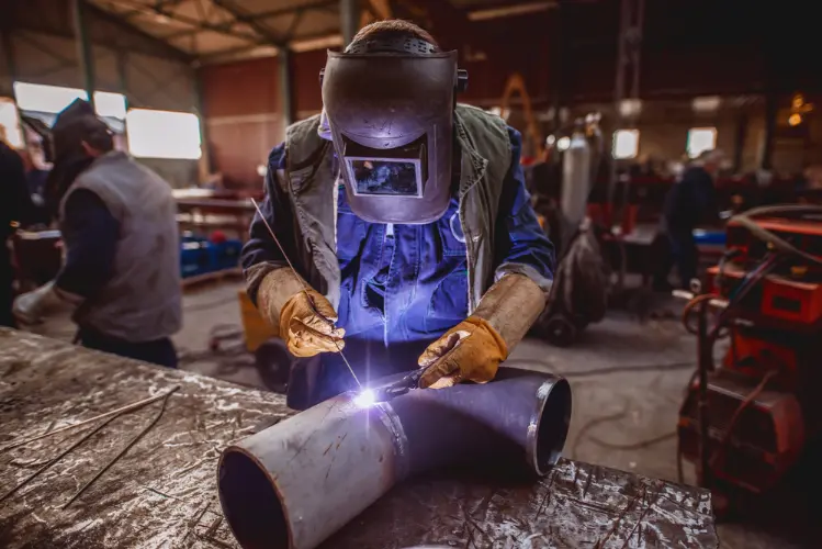 Worker welding pipes